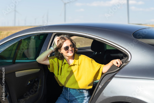 Wallpaper Mural Woman sitting at car with wind farm on the horizon Torontodigital.ca