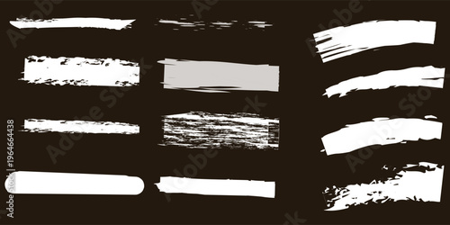 Collection of white acrylic paint brush strokes and chalk smears on dark background