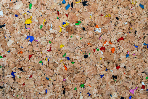 Natural brown cork texture with vibrant multicolored fragments. A sustainable and eco-friendly background ideal for modern office, education, or creative design projects. Colorful recycled cork board