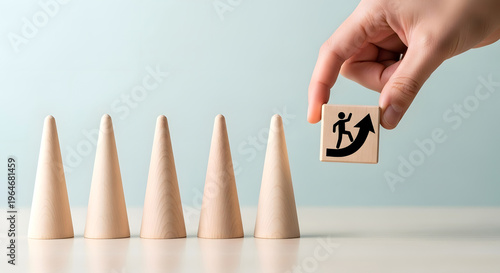 Hand holding wooden block with person climbing arrow