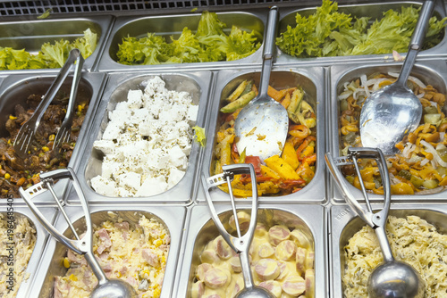 Assorted fresh salads and warm cooked dishes displayed on a self service buffet counter
