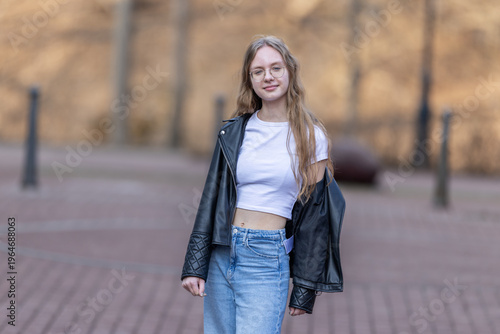 Young Woman In Leather Jacket And Jeans Smiling Outdoors In Casual Street Fashion Portrait
