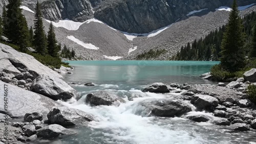 Turquoise Alpine Lake With Rocky Shoreline and Flowing Stream in the Foreground