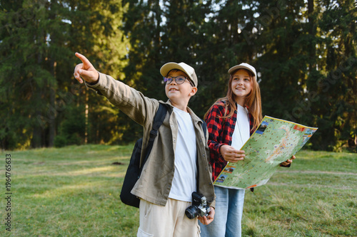 Obraz na plátne Young hikers exploring nature with map and camera, discovering new trails
