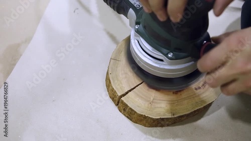 Carpenter sanding a wood with sander