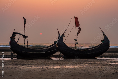 Photography Traditional crescent-shaped moon boats on the beach at sunset.