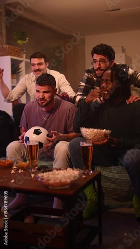 Multicultural group of men celebrating victory while watching football on television. Excited fans enjoying soccer match championship