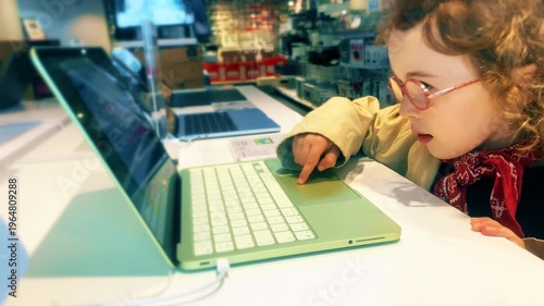 Little Girl Using Laptop Touchpad In Electronics Store