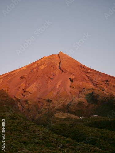 Photography Majestic Mount Taranaki at sunrise with golden alpenglow on volcanic peak, Egmont National Park, New Zealand