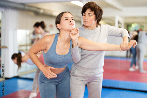 Valokuva Purposeful female pupil clash with training manager during self-defense lesson,
