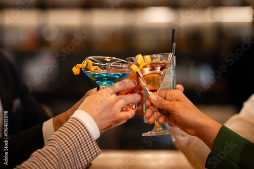 Photography People raising cocktails cheering celebration at bar