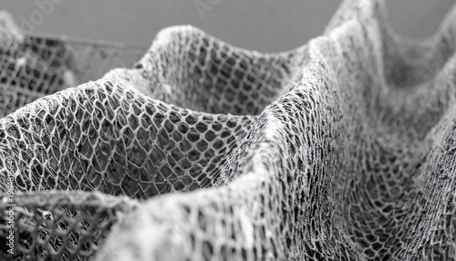 Abstract monochrome wavy mesh texture. Intricate honeycomb pattern on an undulating surface, emphasizing detail and modern design.