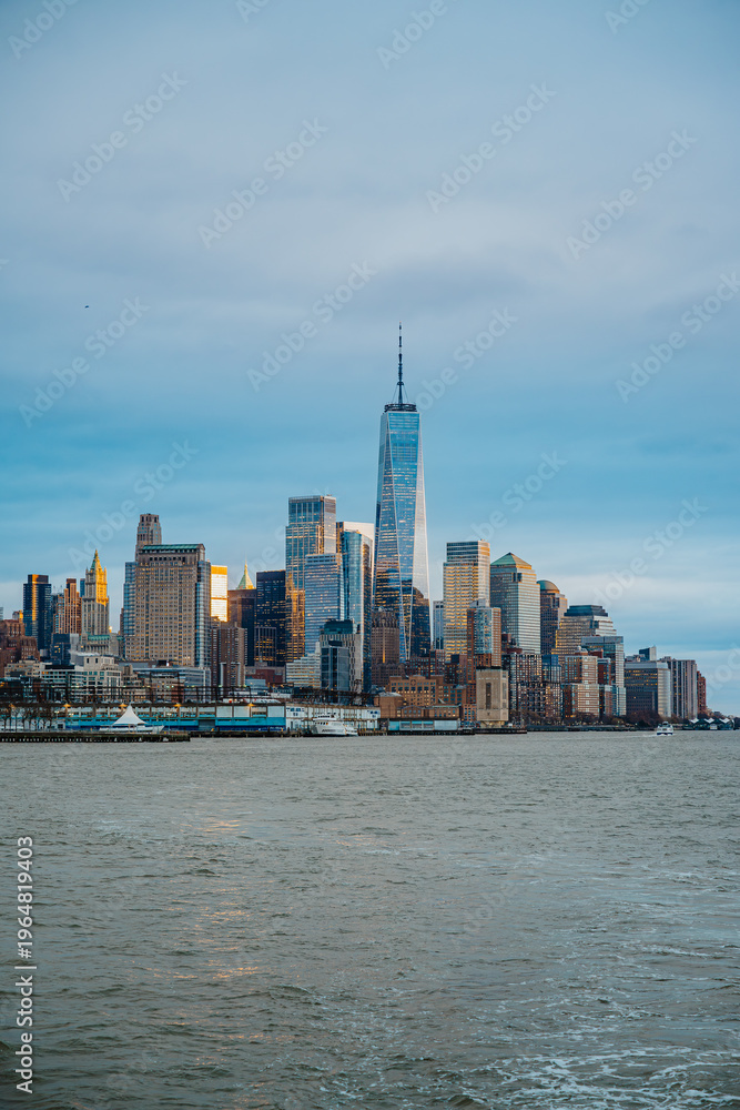 Obraz premium Lower Manhattan skyline with One World Trade Center. Panoramic view of Financial District skyscrapers and One World Trade Center over the Hudson River on overcast day.