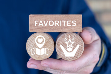 Concept of favorites. Person holding wooden blocks with icons sees the text FAVORITES.