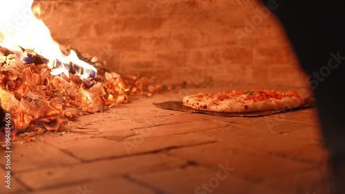 4K Pizza baking inside a wood-fired oven with visible flames and crispy crust Traditional Italian cooking, Concept ideal for restaurant food.