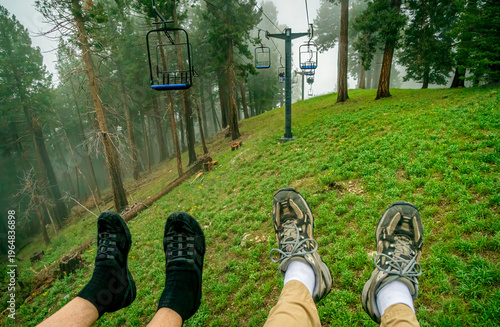 People ride a ski lift in the clouds and fog on a summer day in the Santa Catalina Mountains near Tucson Arizona