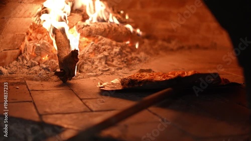 4K Pizza baking inside a wood-fired oven with visible flames and crispy crust Traditional Italian cooking, Concept ideal for restaurant food.
