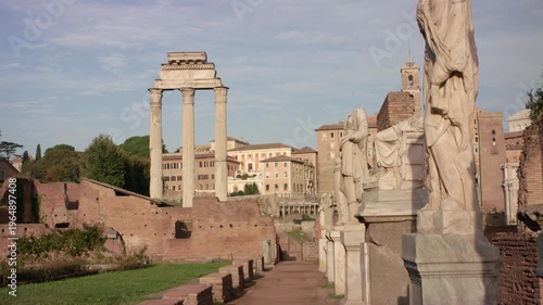 Ancient Roman Forum in Rome with standing columns and marble statues among historic ruins under soft daylight creating timeless archaeological landscape in Italian city