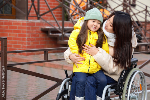 Young Asian mother in wheel...