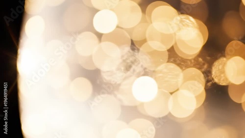 A blurry background of shimmering gold lights on a dark setting