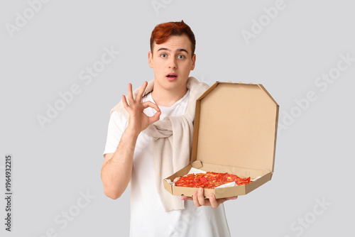 Surprised young man holding...