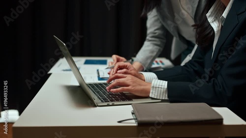 Businesswomen analyzing financial data on a laptop