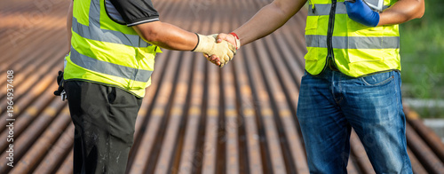 Two engineers shake hand in rail Industrial meeting cooperation, engineers team in Construction site handshake Workers for Deal Agreement Partnership in Engineering Field