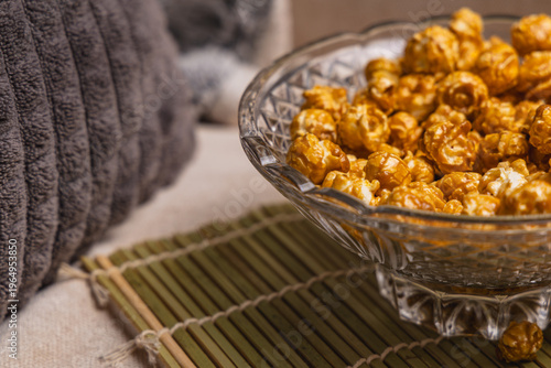 Fotografía Bowl of caramel popcorn sits on a table beside a cozy pillow