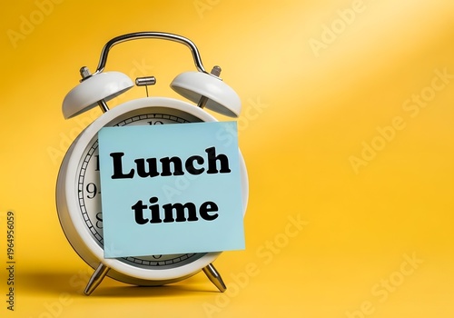 Alarm clock with a sticky note that says lunch time on a yellow background