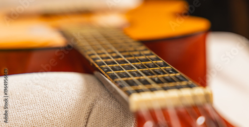 Foto Close view of guitar resting on couch with focus on strings and body