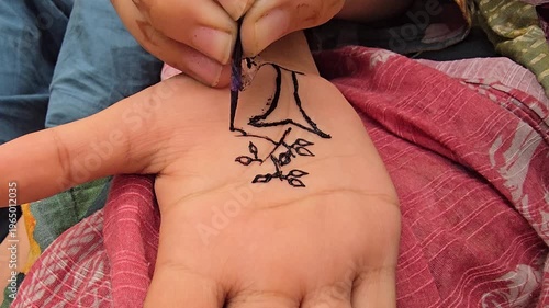 Henna design being created on a hand with intricate patterns and artistic details in black ink