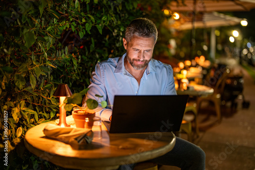 Fotografie Businessman working on laptop outdoor