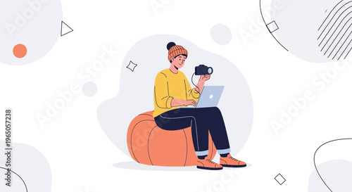 Creative freelancer with camera and laptop working remotely on bean bag chair
