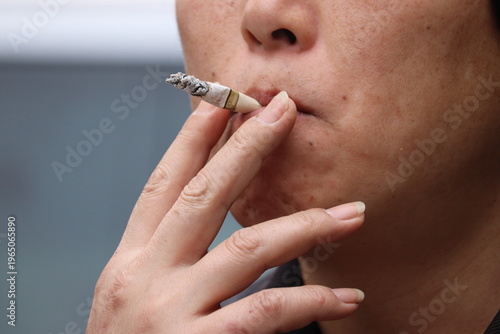 Close-up of a person smoking a nearly finished cigarette, highlighting nicotine addiction and stress relief behavior