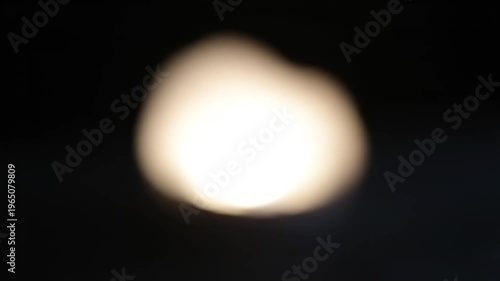 Blurry white light in darkness.