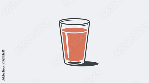 A glass of juice is sitting on a plain surface in a minimalist setting.