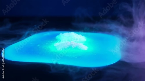 Mystical blue smoke swirling mysterious glowing surface in the dark