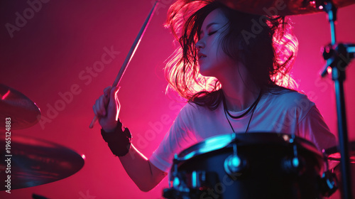 Energetic female drummer performance rock music stage, passionate asian musician playing drum set under colorful concert light, dynamic hair movement and intense focus