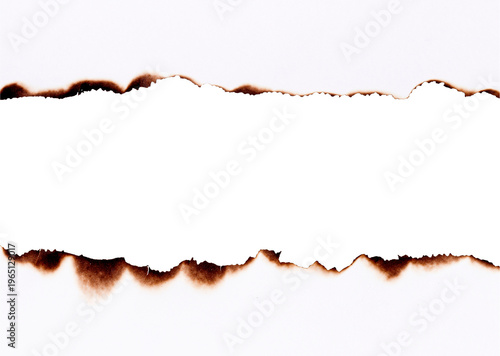 Burnt paper with torn charred edges forming a damaged border frame isolated on white background