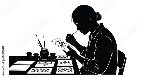 Artist meticulously painting intricate designs on small tiles with focused concentration