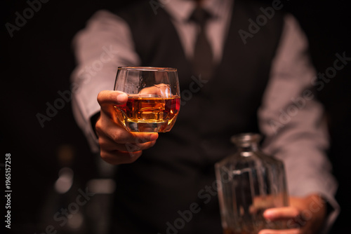 Bartender Holding Out a Glass of Premium Whiskey to Customer