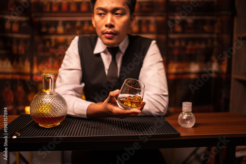 Bartender Holding a Glass of Premium Whiskey on Bar Counter