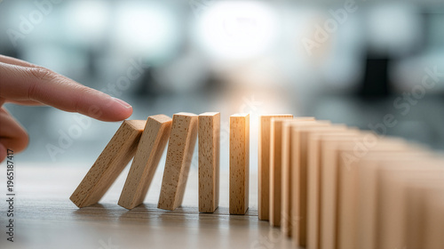 Risk Management Concept With Hand Starting Domino Effect On Desk And Soft Office Blur