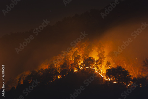 Tableau sur toile Wildfire smoke pollution over burning mountain forest at night creating fearful