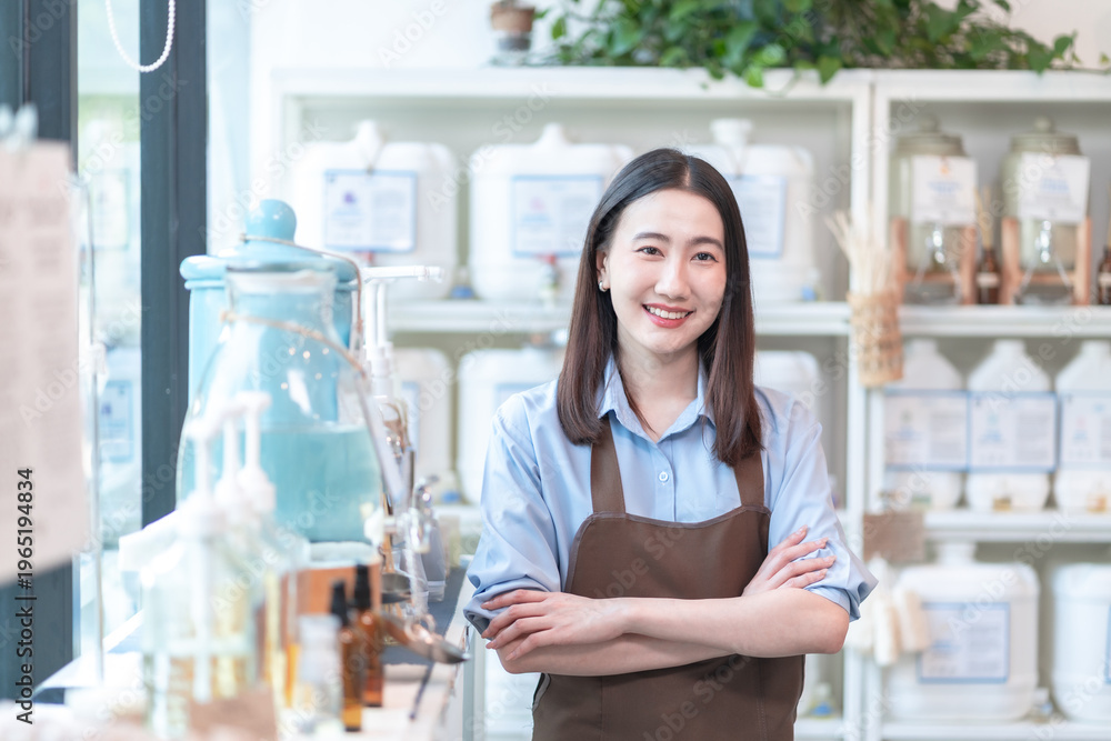 Ταπετσαρία Proud and confident Asian shopkeeper in a brown apron stands with arms crossed and a bright smile inside her eco organic store, embodying female entrepreneurship and success
