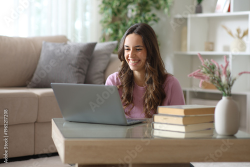 Happy woman using laptop over a coffee table