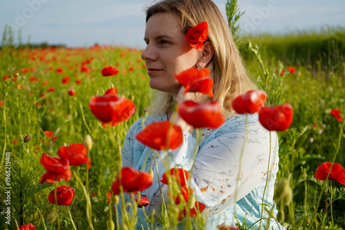 Lost among the poppies in a dress of soft blue. Somewhere between the sky and these scarlet fields, everything feels perfectly still.