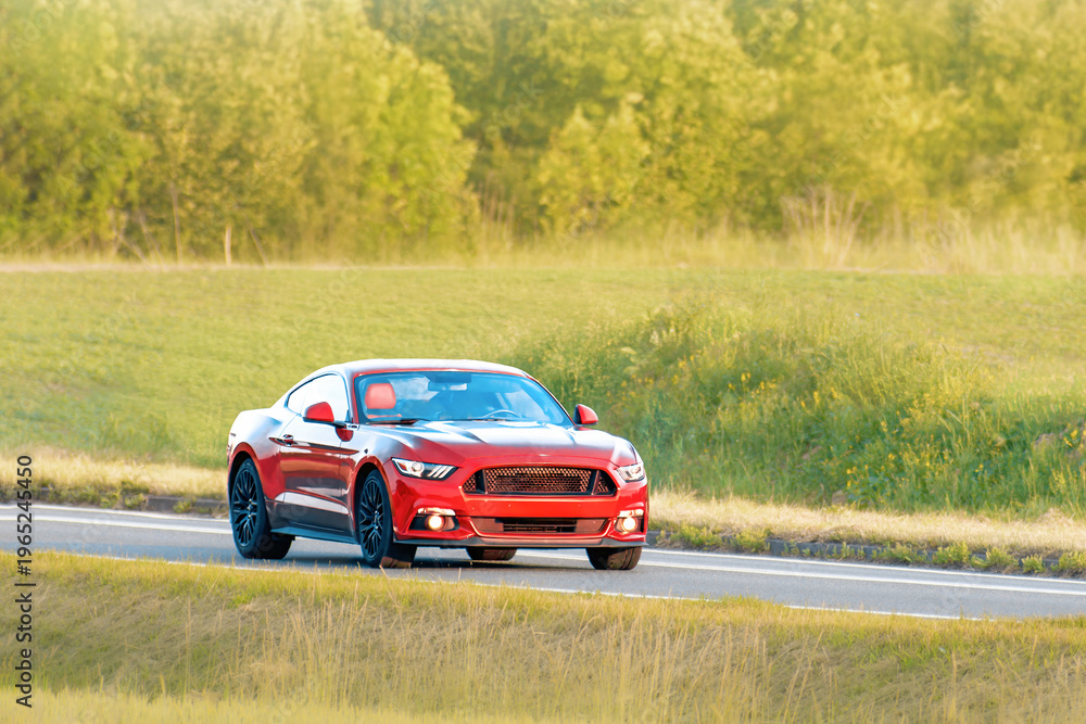 Fototapeta premium Customized red roadster driving on asphalt highway