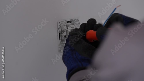 
Electrician Installing Light Switch on White Wall — Close Up Hand Detail