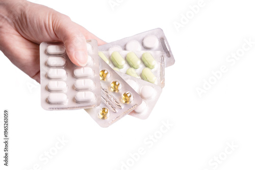 Obraz na płótnie Hand holding assortment of medical capsules and pills in blister packets, close up